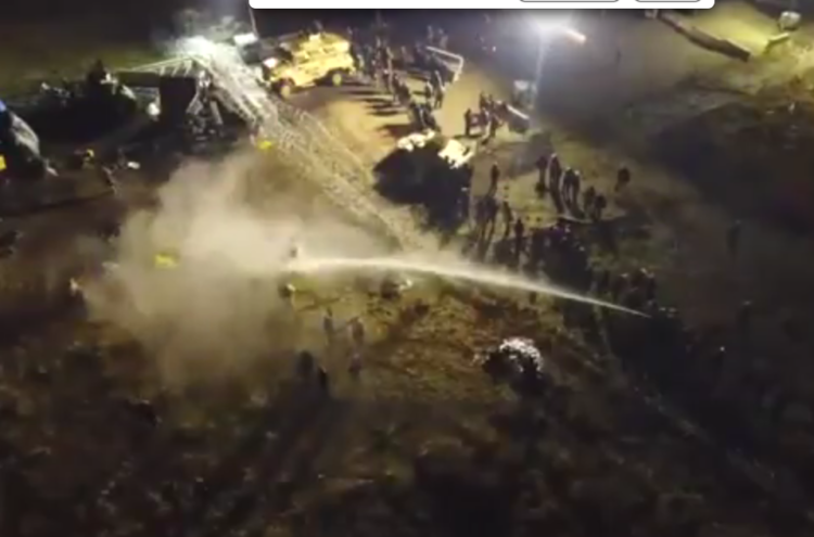 Drone footage captures police spraying Dakota Access Pipeline protesters with a water cannon.